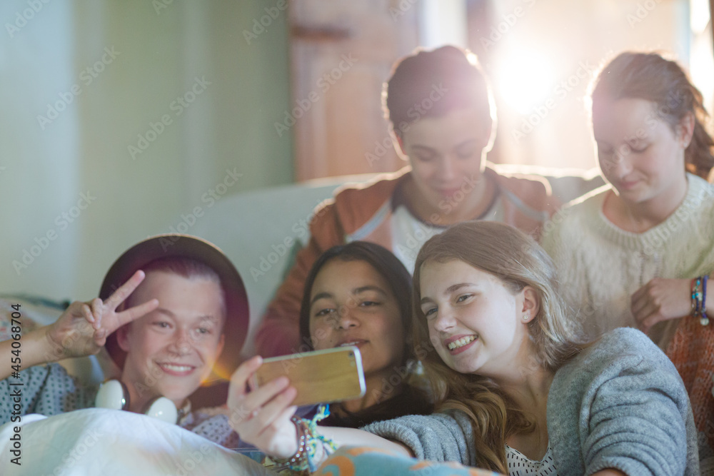 Group of teenagers taking selfie on sofa in living room Group of teenagers taking selfie on sofa in living room
