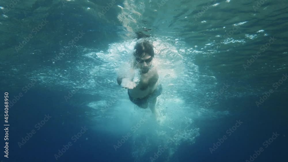 Ragazzo nuota nel mare in stile libero visto da sott'acqua Ragazzo nuota nel mare in stile libero visto da sott'acqua