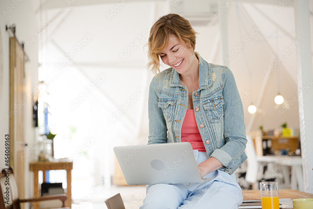 Obraz premium Portrait of woman sitting at desk with laptop in office