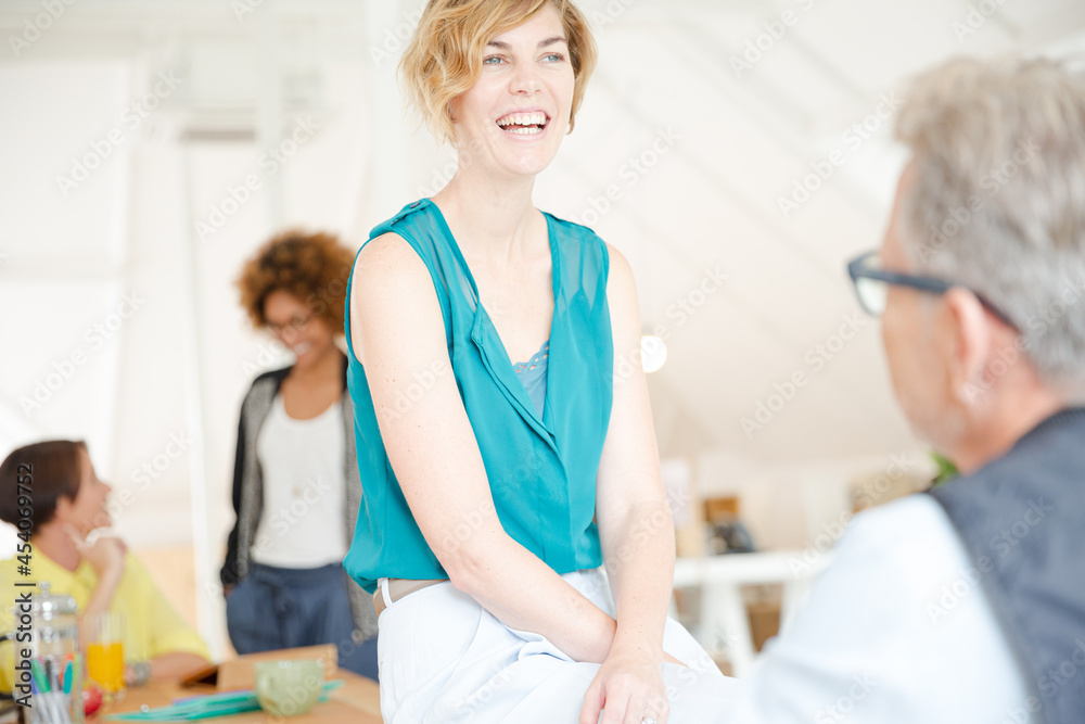 Obraz premium Man and woman sitting in office,smiling and talking