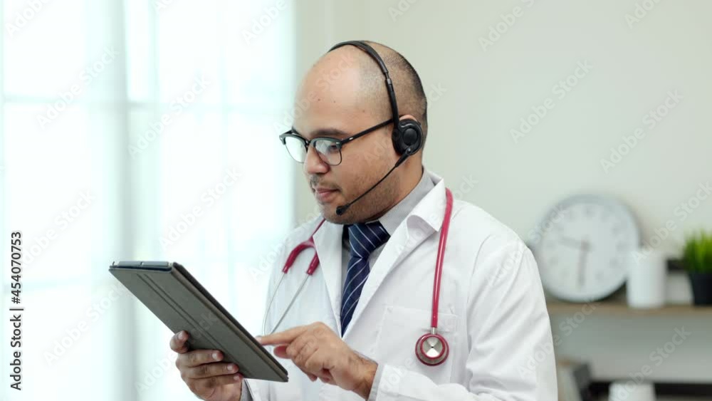 Doctor talks to patient via online video conferencing looking at screen. Explain about taking medications to treat illnesses and note the report with tablet.
Doctor talks to patient via online video conferencing looking at screen. Explain about taking medications to treat illnesses and note the report with tablet.