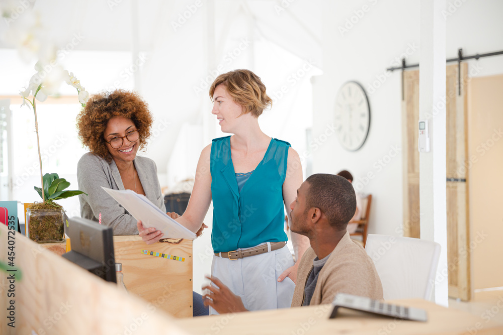 Office workers talking at desk Office workers talking at desk