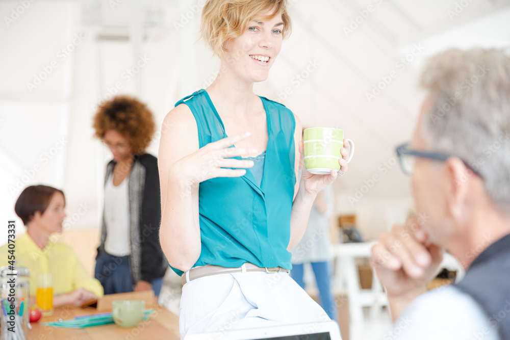 Man and woman sitting in office,smiling and talking Man and woman sitting in office,smiling and talking