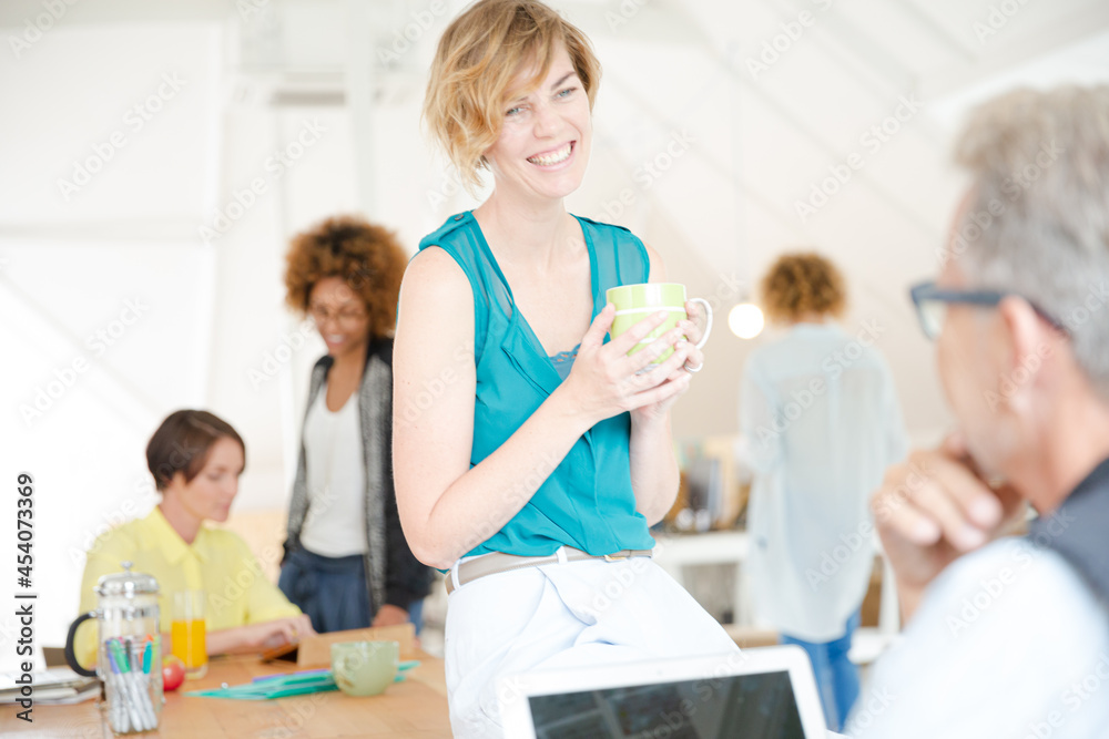 Man and woman sitting in office,smiling and talking Man and woman sitting in office,smiling and talking