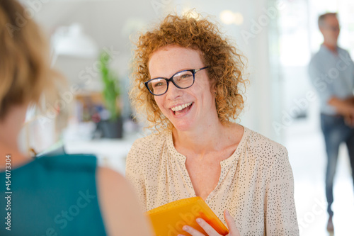 Women talking and smiling in office