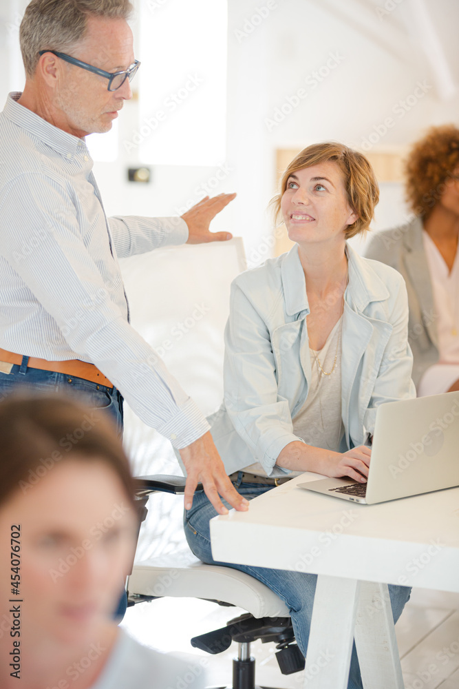Office workers talking at desk