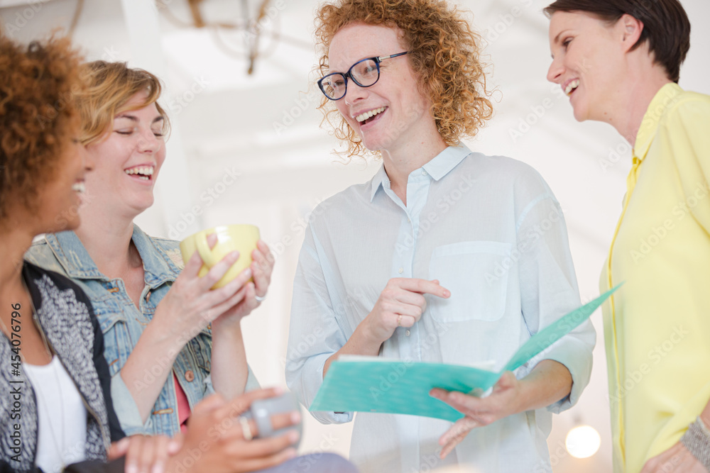 Fototapeta premium Women with coffe cup talking in office