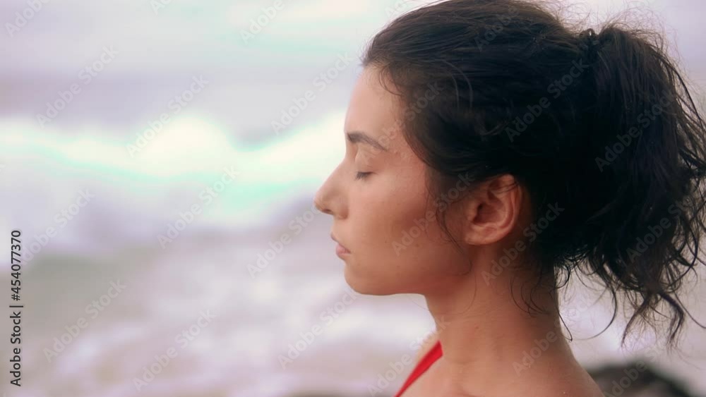 Young asian woman doing breathing exercises on the ocean beach. Brunette relaxing and enjoy beauty sunlight. Girl doing yoga and meditation on the sea coast. Concept of yoga, relaxation, paradise. Young asian woman doing breathing exercises on the ocean beach. Brunette relaxing and enjoy beauty sunlight. Girl doing yoga and meditation on the sea coast. Concept of yoga, relaxation, paradise.