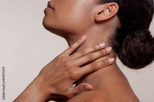 Young woman touching neck
