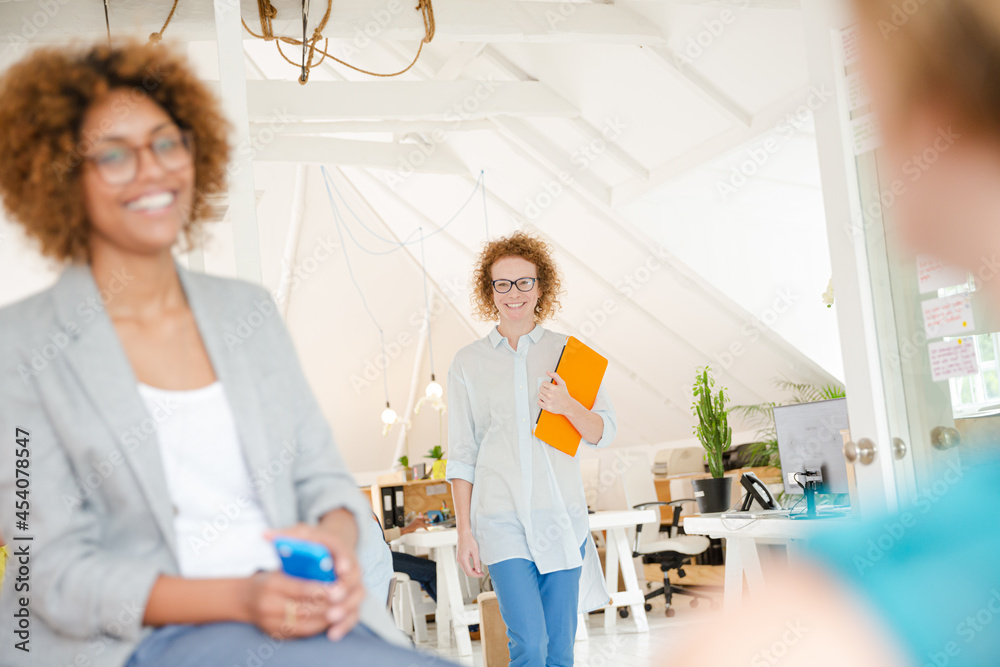 Obraz premium Woman walking and carrying laptop, joining colleague from office