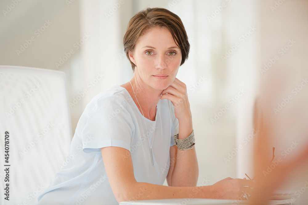 Portrait of woman sitting at desk in office Portrait of woman sitting at desk in office