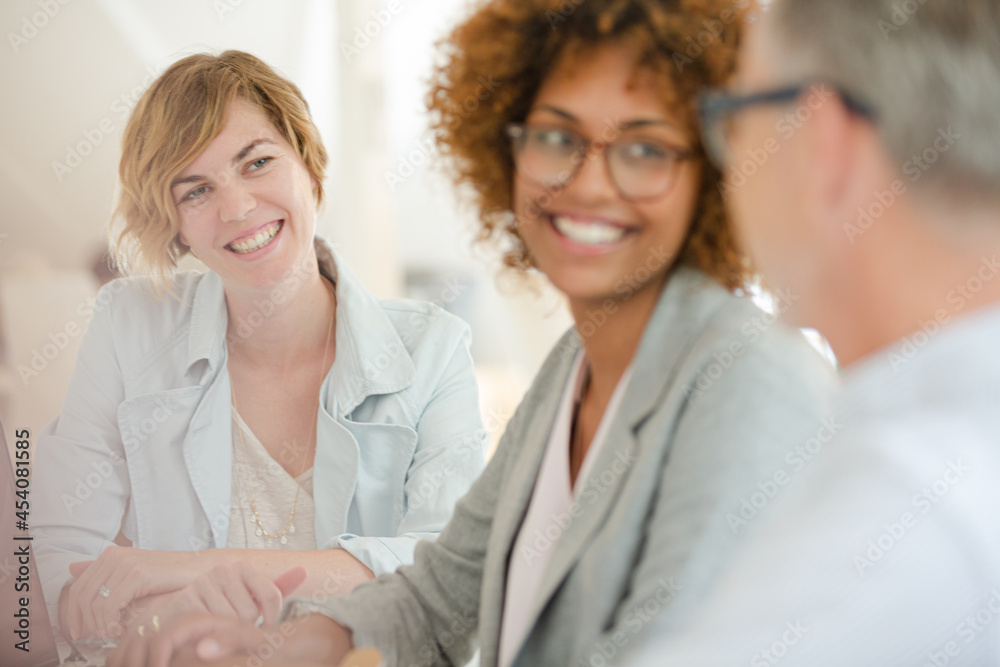 Obraz premium Three office workers talking at desk with laptop