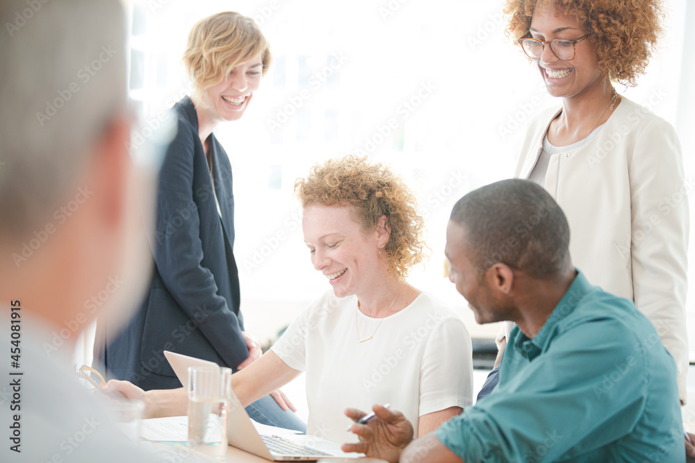 Office workers talking and smiling at meeting Office workers talking and smiling at meeting