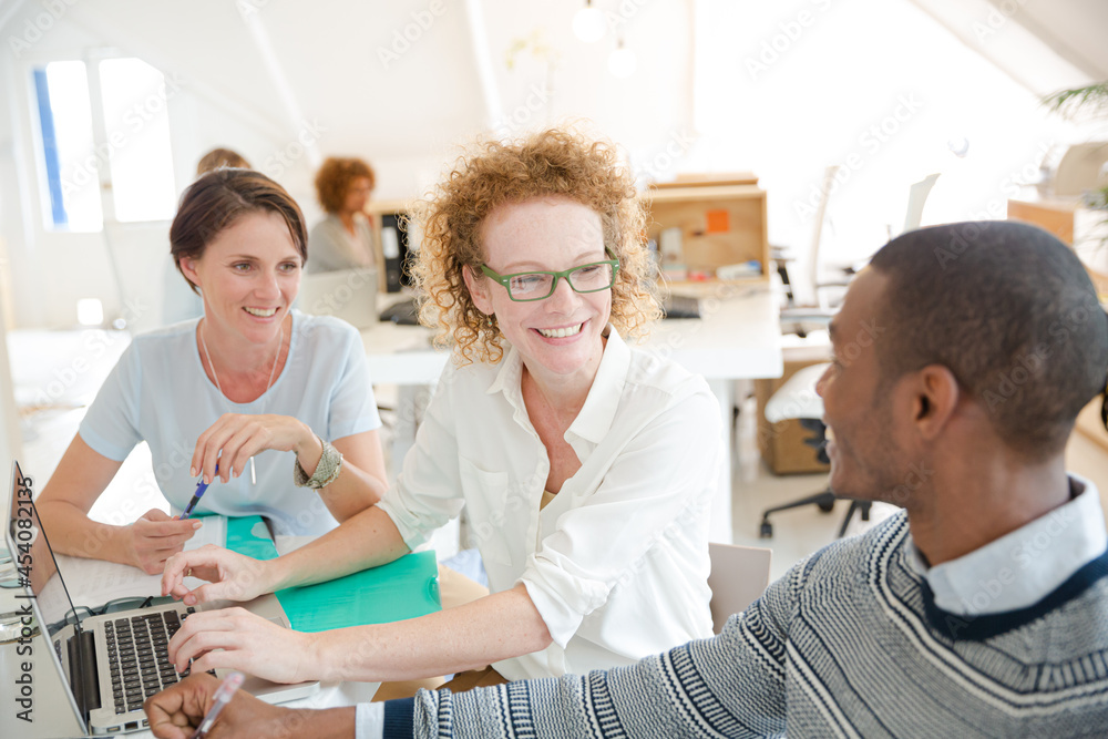 Obraz premium Office workers talking over laptop at desk