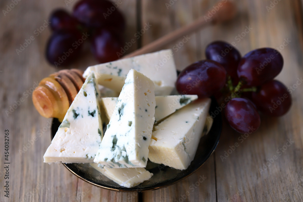 Gorgonzola or Dor Blue cheese with grapes and honey. Keto snack. Healthy food.