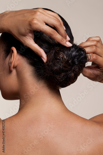Young woman touching hair bun
