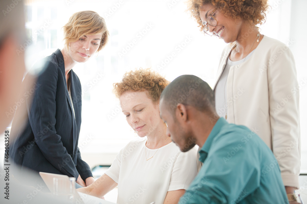 Office workers talking and smiling at meeting