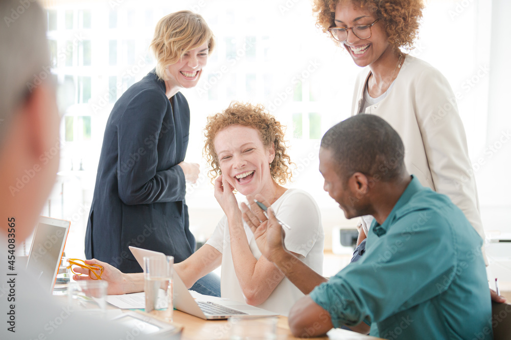 Office workers talking and smiling at meeting Office workers talking and smiling at meeting