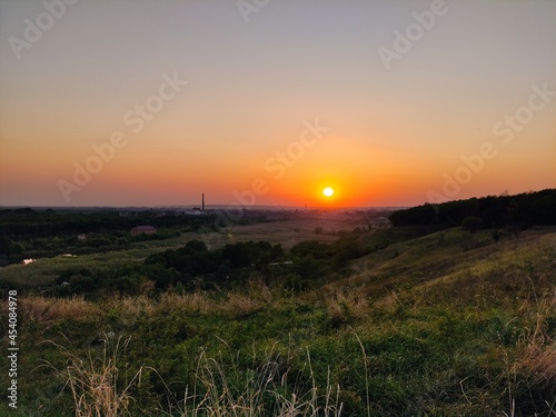 Evening landscape, city, valley, plant tubes and sunset