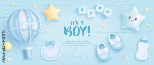 Baby shower horizontal banner with cartoon hot air balloon, baby shoes, helium balloons and flowers on blue wooden background. It's a boy. Vector illustration