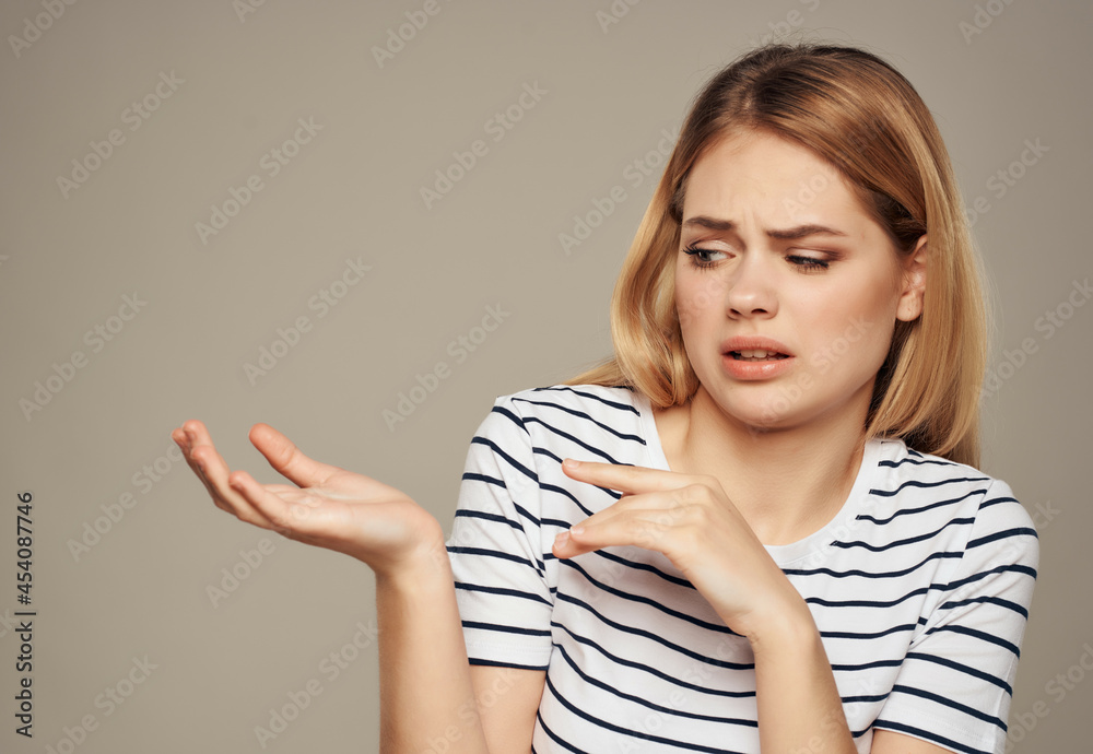 disgruntled woman in striped t-shirt gesturing with her hands disgruntled woman in striped t-shirt gesturing with her hands