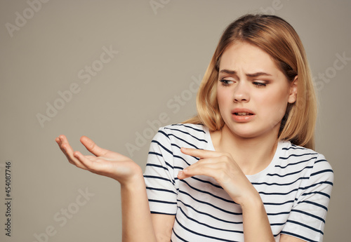 disgruntled woman in striped t-shirt gesturing with her hands