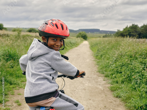 Portrait of boy riding bicycle in countryside photo