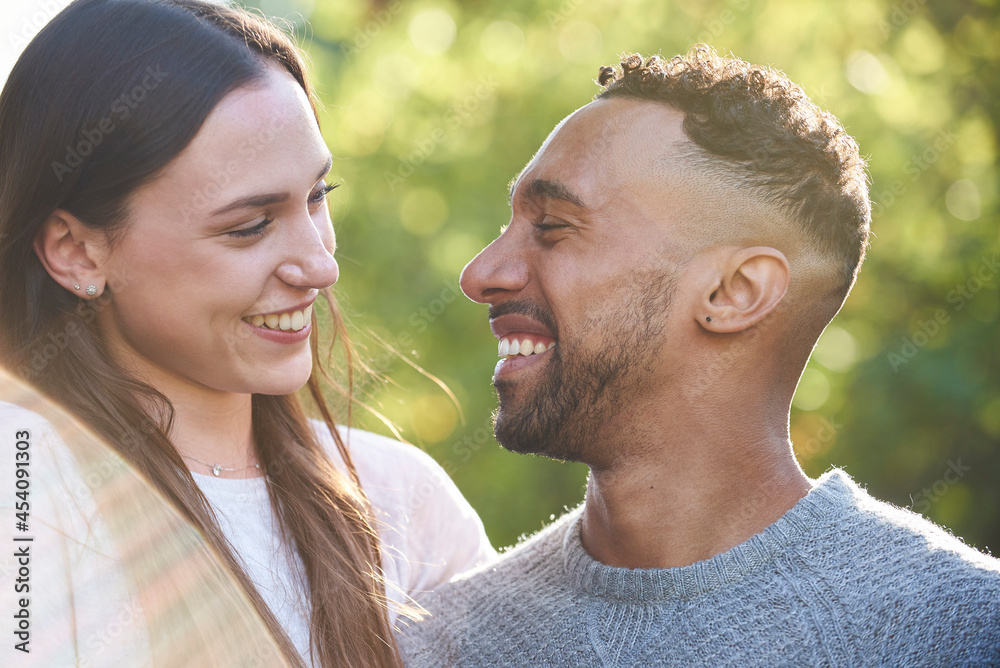 Close-up of smiling young couple looking at each other in public park Close-up of smiling young couple looking at each other in public park