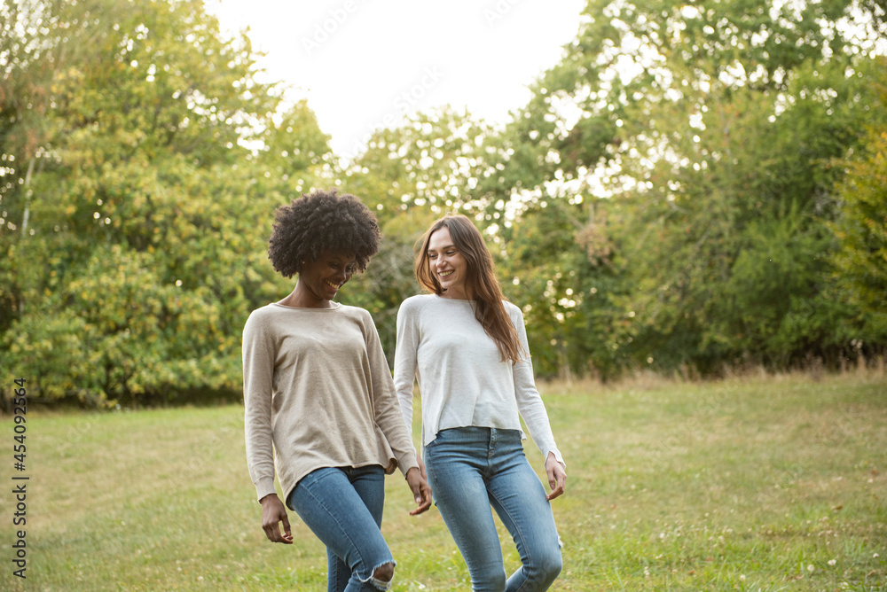 Smiling young female friends walking in park Smiling young female friends walking in park