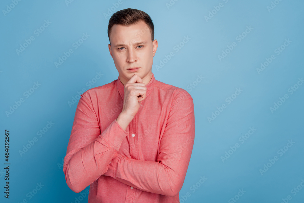 Portrait of smart celver guy hand chin look camera have thoughts on blue background Portrait of smart celver guy hand chin look camera have thoughts on blue background