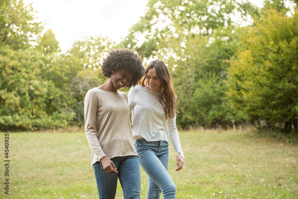 Smiling young female friends walking in park Smiling young female friends walking in park