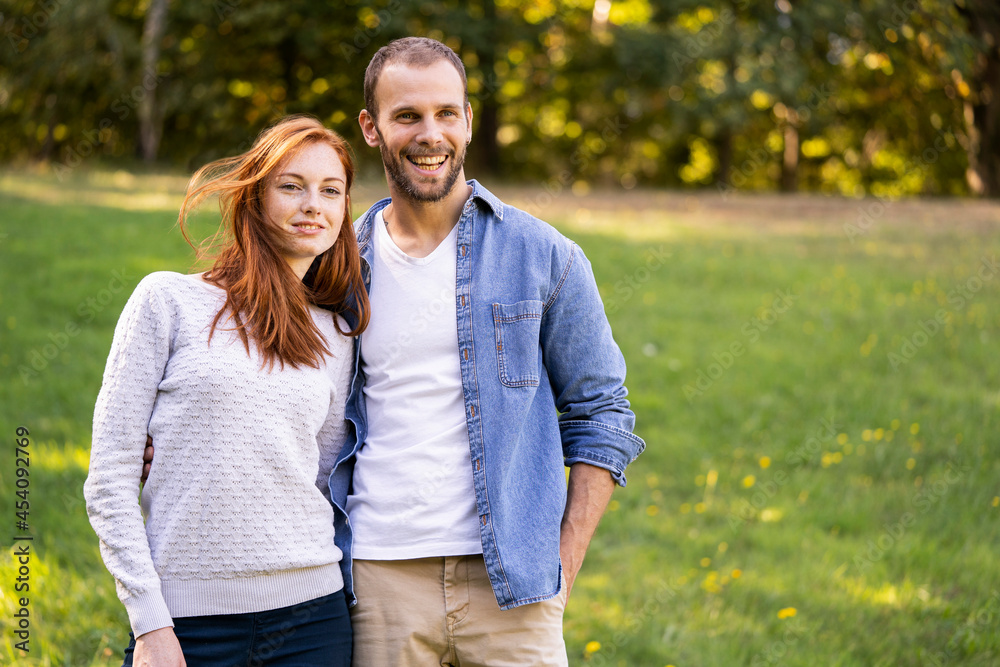 Portrait of smiling young couple enjoying a stroll in a park Portrait of smiling young couple enjoying a stroll in a park