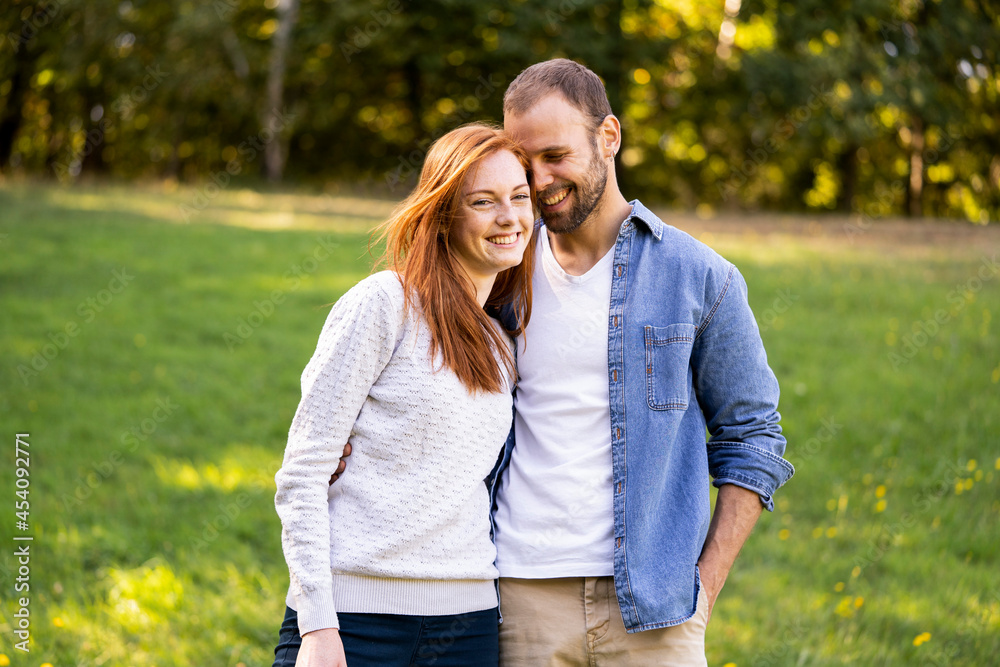 Portrait of smiling young couple enjoying a stroll in a park Portrait of smiling young couple enjoying a stroll in a park