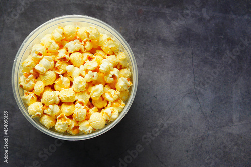  popcorn in a bowl on black tiles background 