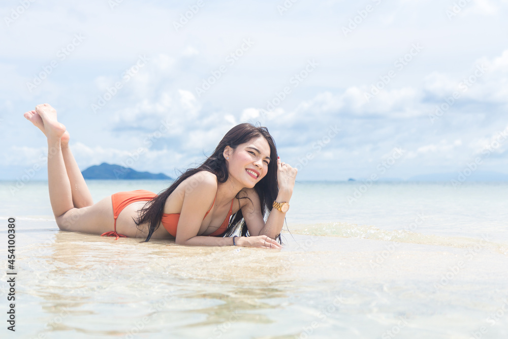 Beautiful young woman enjoying in sunbathing on the beach.