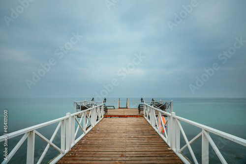 Fototapeta Naklejka Na Ścianę i Meble -  Pier with wooden plank flooring and hammocks to liven up the wait while enjoying the maritime horizon