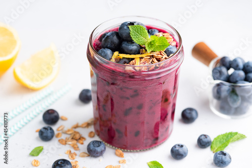 Konstfotografi Organic thick acai blueberry smoothie in glass jar, white background