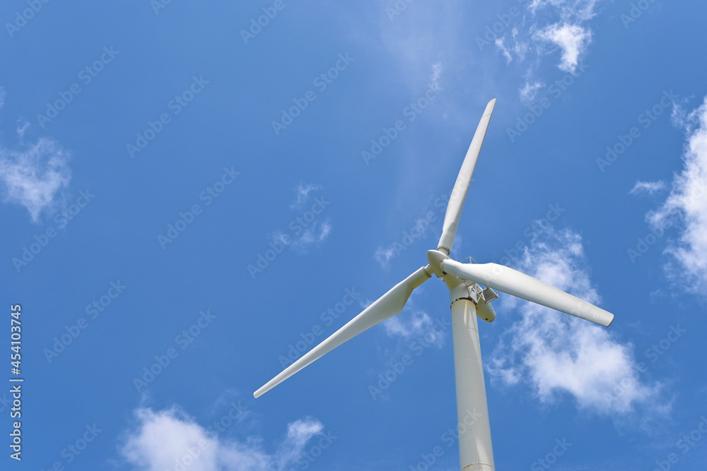 A single wind turbine for clean energy to solve a global warming problem under beautiful vast blue sky.