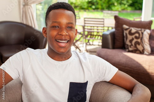 Smiling teenage boy sitting in armchair photo