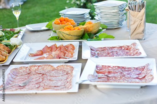 Open air buffet. Slicing different types of sausages