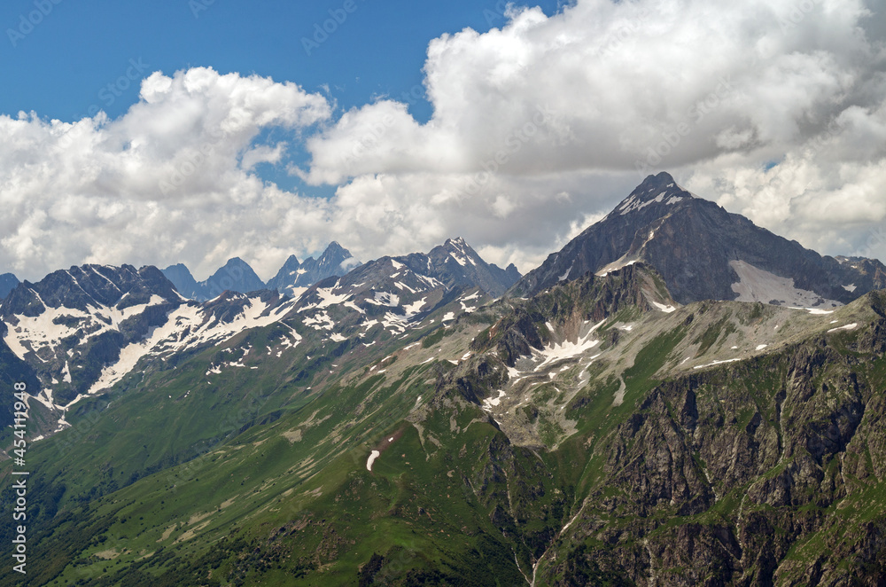 Beautiful mountain landscape of the Caucasus mountain range. Mountain peaks and clouds.