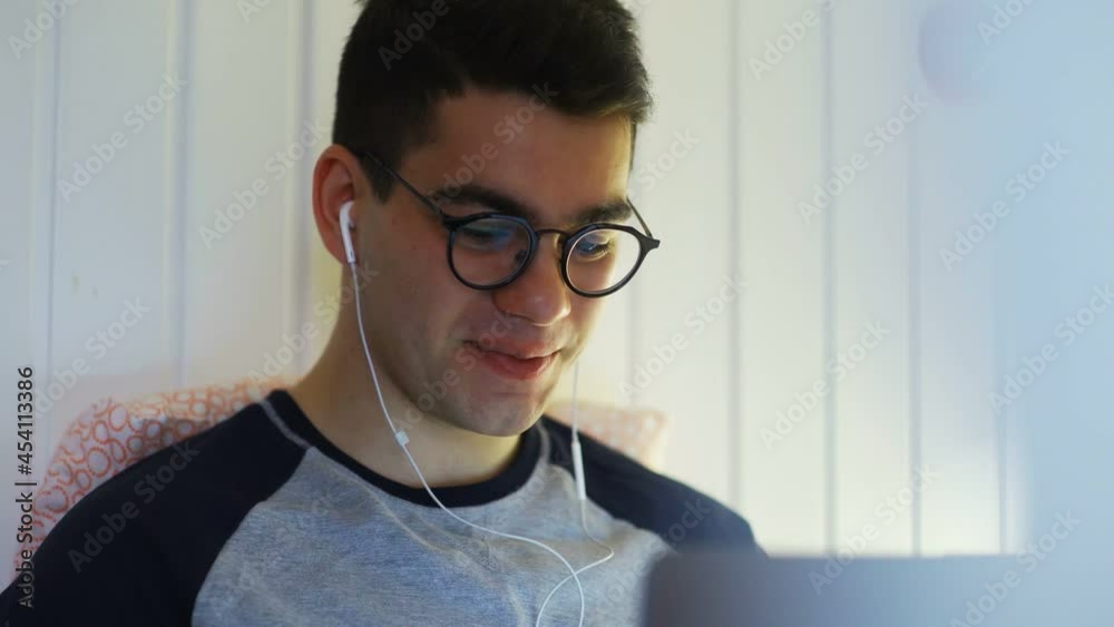 Close-up of a young man lying on a bed and working on a laptop, typing on a keyboard, working at night, remote work from home at night. Close-up of a young man lying on a bed and working on a laptop, typing on a keyboard, working at night, remote work from home at night.