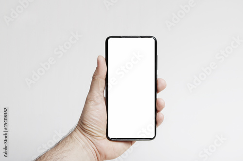 Obraz na płótnie Smartfon w ręce na jasnym tle w salonie