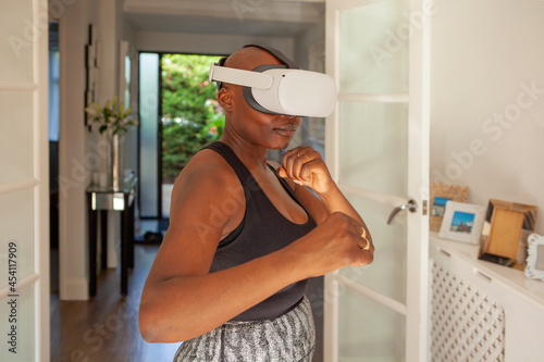 Mature woman practicing boxing with virtual reality simulator