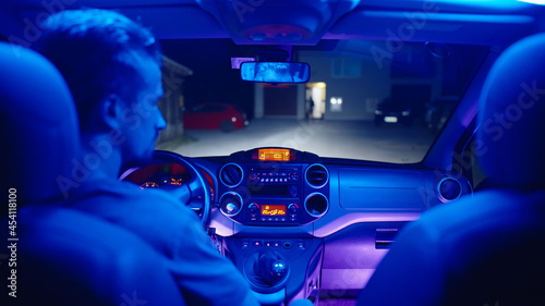 Neon lights glow inside the car while driving at night