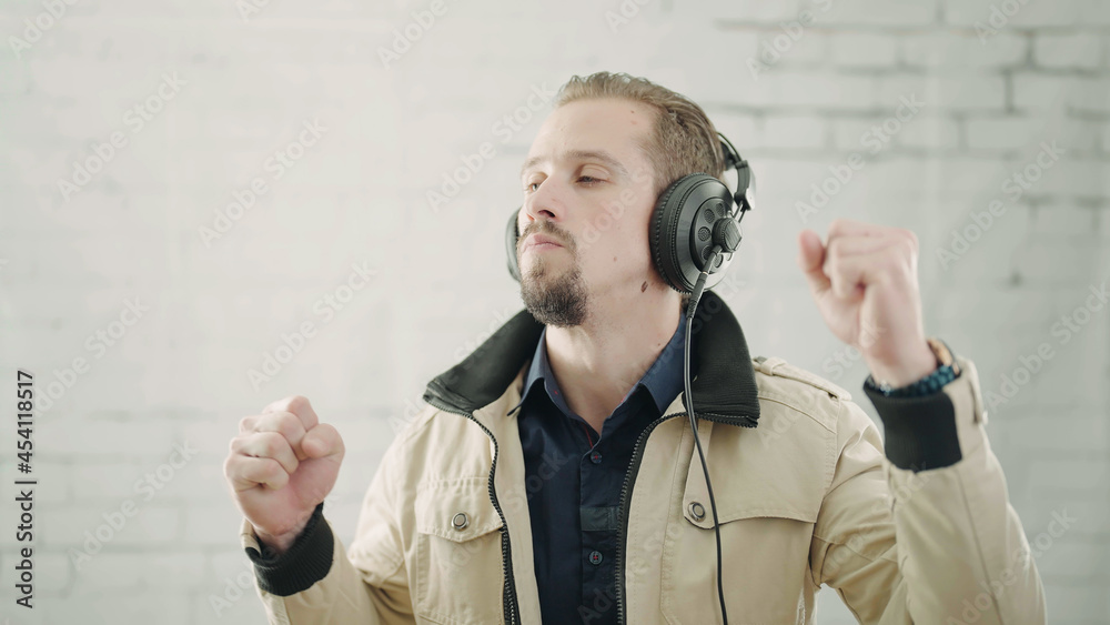 Naklejka premium Man listening to music on earphone while dancing