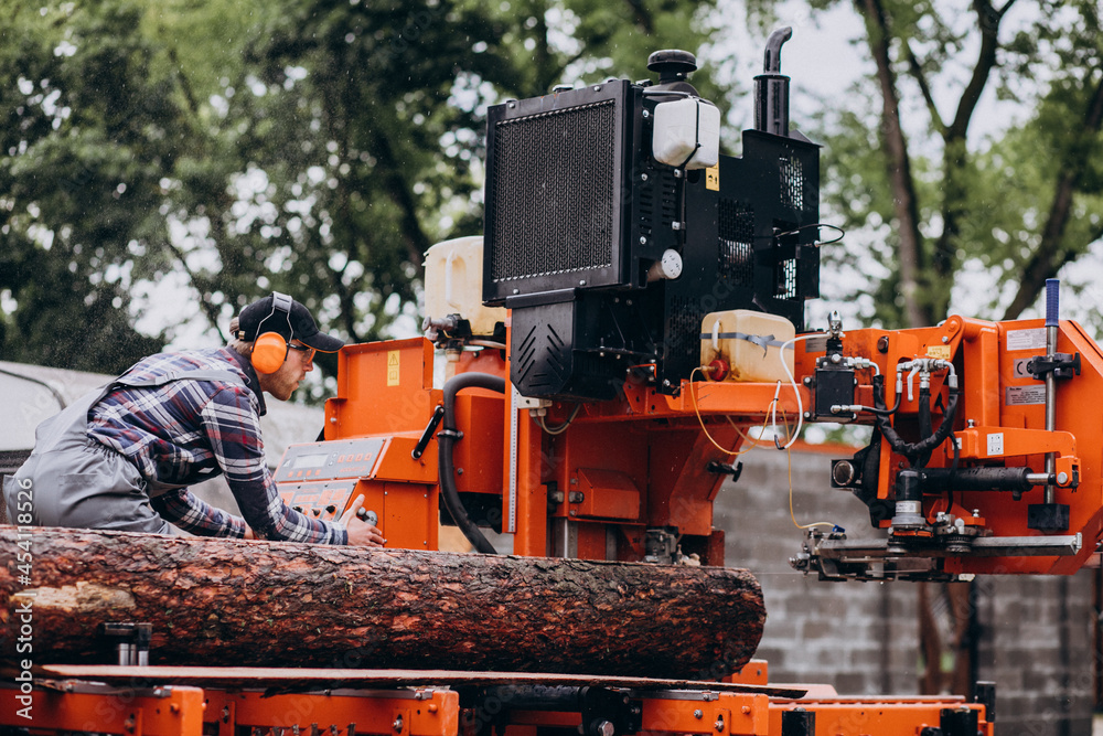 Carpenter working on a sawmill on a wood manufacture Carpenter working on a sawmill on a wood manufacture