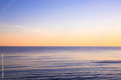 View from beach at sunset with ocean, colorful sky and sea