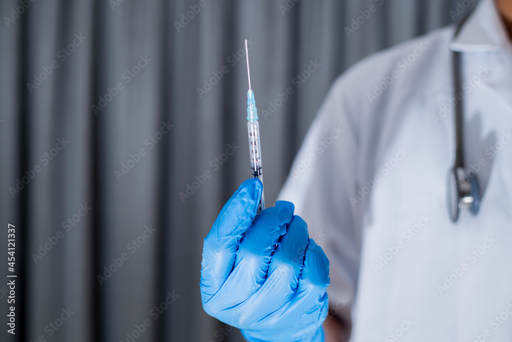 Closeup shot of unrecognizable doctor hand holding vaccine syringe wearing protective glove. Closeup shot of unrecognizable doctor hand holding vaccine syringe wearing protective glove.