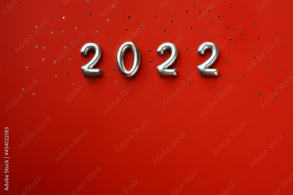 Silver numbers 2022 new year and glitters on red background, copy space . Silver numbers 2022 new year and glitters on red background, copy space .